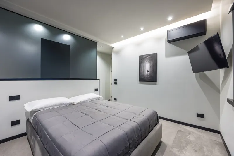 Letto con copriletto grigio e parete testata in vetro, camera di Santopaolo 2