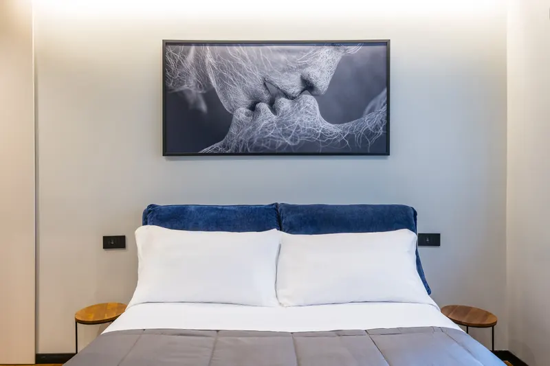 Camera di Santopaolo 3, letto con testata blu e quadro in bianco e nero