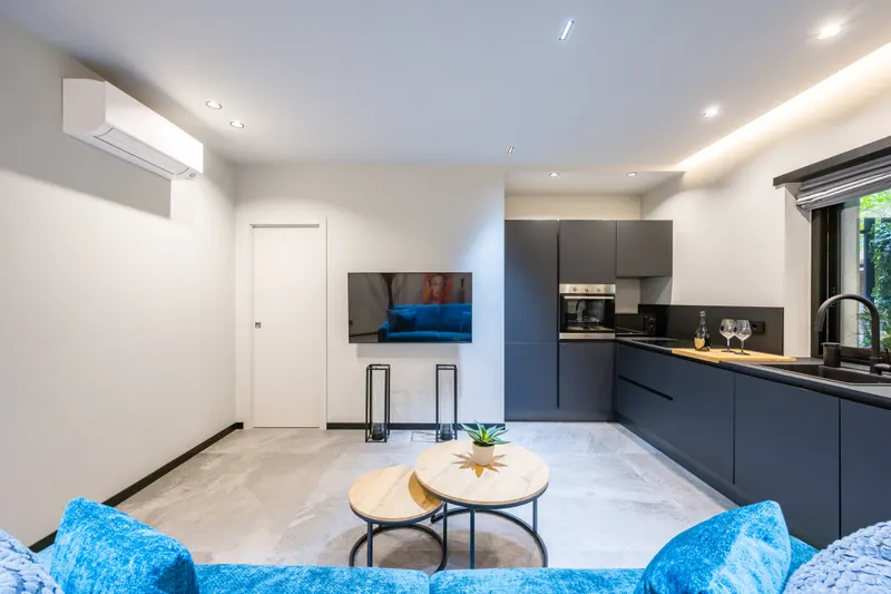 Divano blu, tavolini e cucina, salone di Santopaolo 4